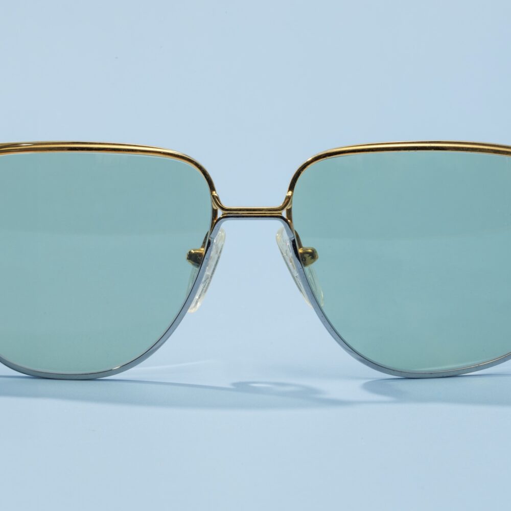 Lunettes de soleil vintage des années 70 de la maison de luxe Valentino. Monture en acier argenté et doré fabriquée main en Italie d'un savoir-faire lunetier authentique, avec des verres verts fantastiques. Les lunettes Valentino sont toutes fabriquées à la main, avec des matériaux soigneusement choisis.